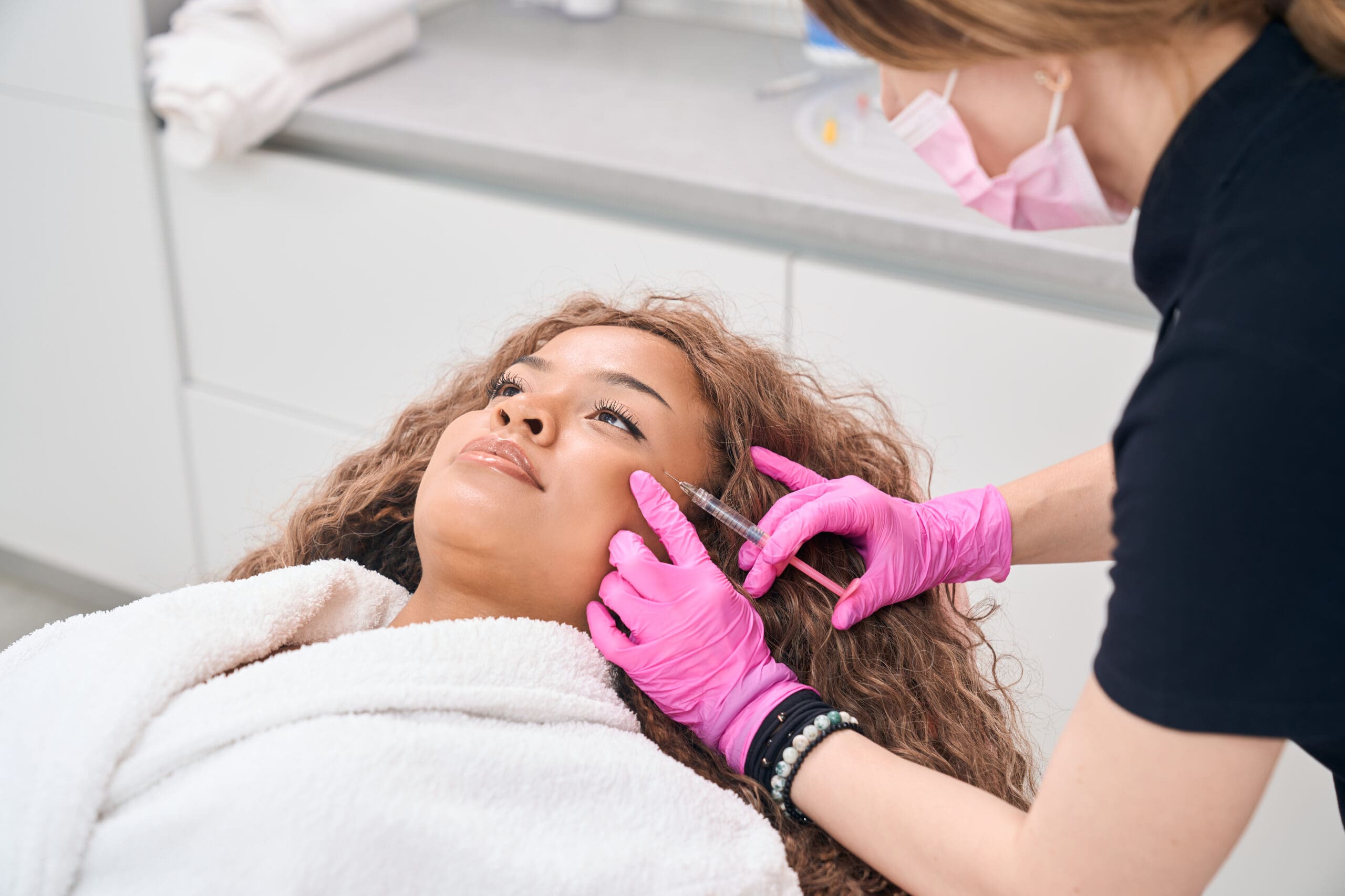 Woman receives botulinum toxin injections in clinic of aesthetic medicine | Passion Beauty Academy A woman receiving Botox injections in a clinic, highlighting the need for a skilled injector to ensure safe and effective cosmetic results.